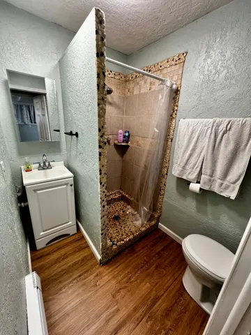 Walk-in shower with pebble tile accents and a built-in corner shelf