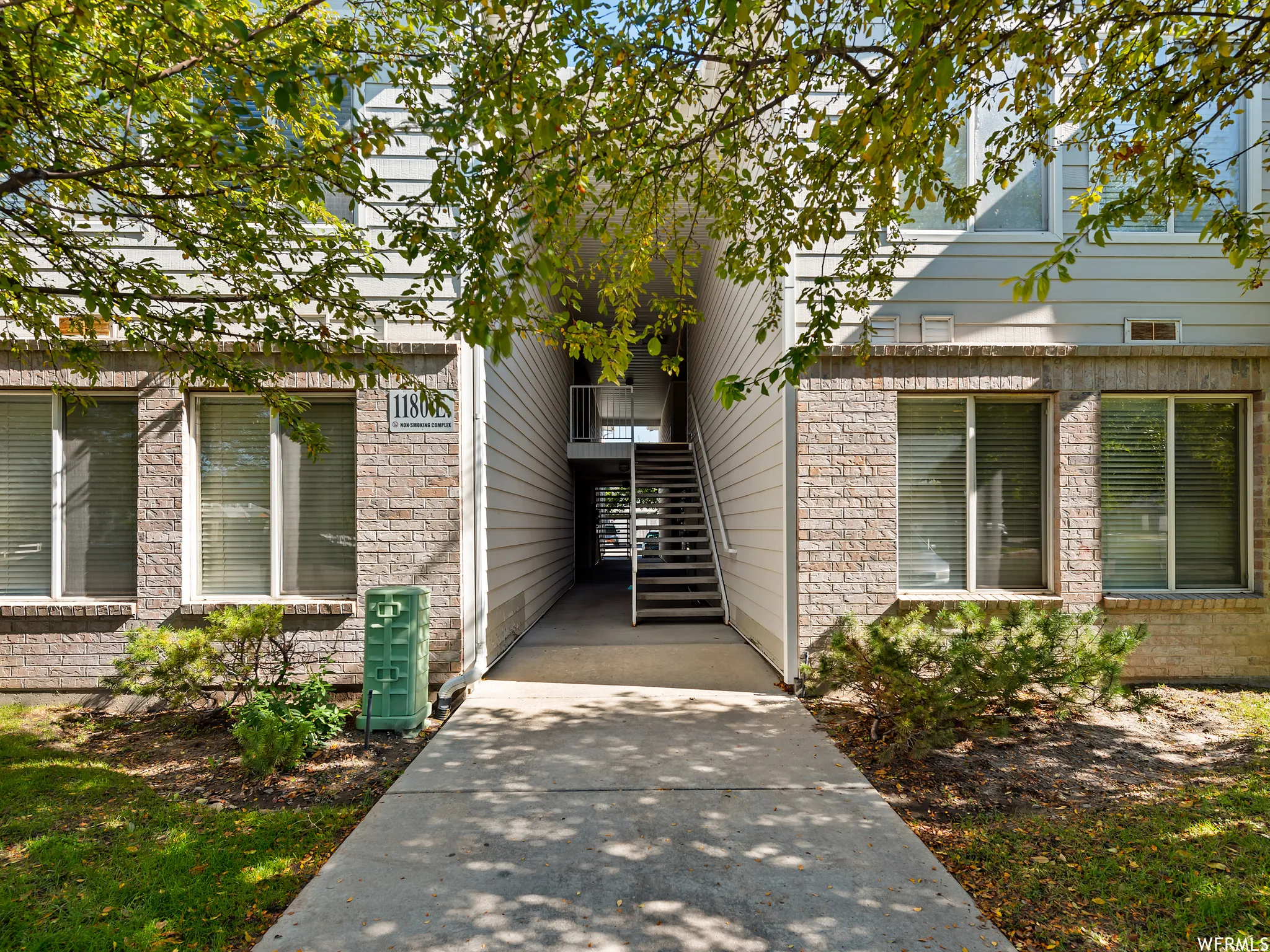 Building exterior featuring brick and horizontal siding, with a central entryway and staircase