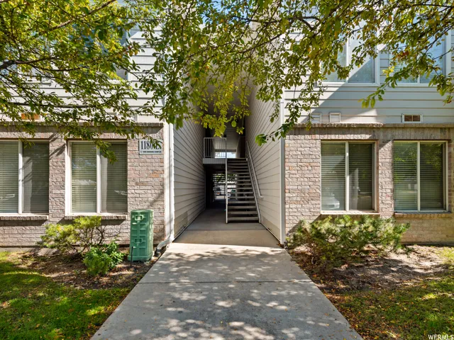 Building exterior featuring brick and horizontal siding, with a central entryway and staircase