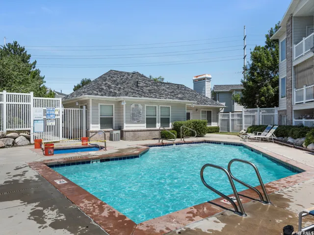 Community swimming pool featuring a concrete deck and integrated hot tub