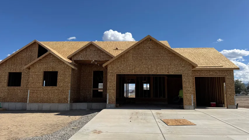 New construction home featuring sheathed exterior walls, a two-car garage opening, a single-car garage opening, and a concrete driveway