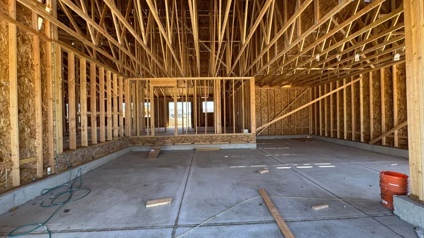 New construction framing featuring structural wood studs and exposed ceiling trusses