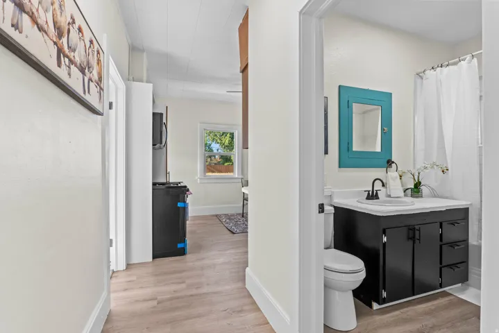 Bathroom featuring a black vanity with white countertop, contemporary black faucet, and a shower with white curtain