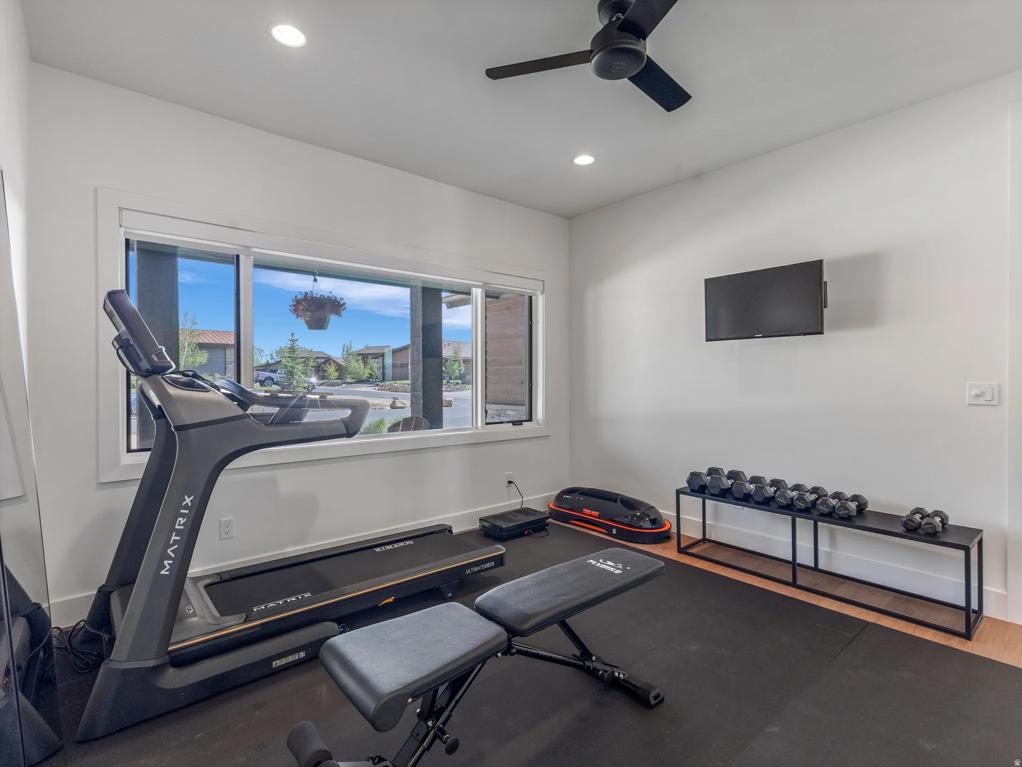 Dedicated fitness space featuring rubberized flooring, recessed lighting, and a ceiling fan