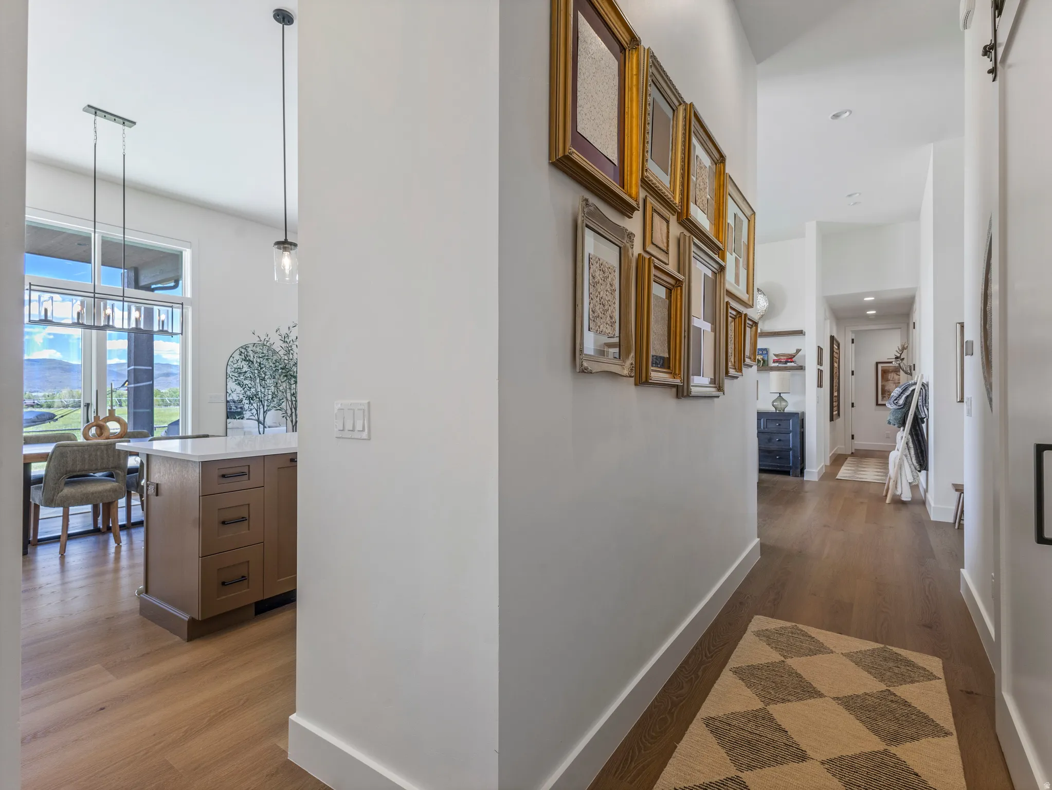 Modern interior hallway with wood-finish flooring, white baseboards, and overhead recessed lighting