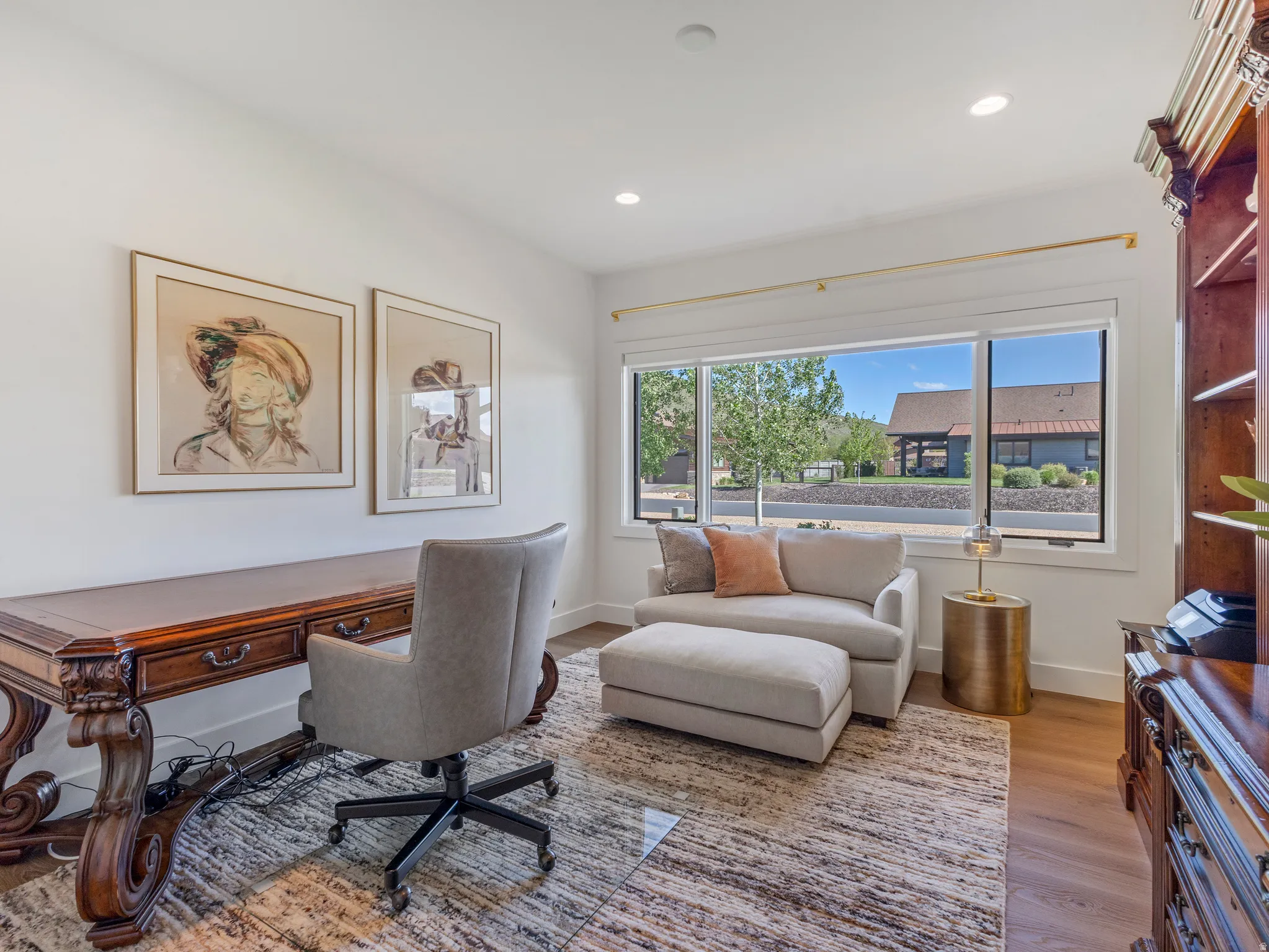Bright room featuring wood-finish flooring, a large window with white trim, and recessed lighting