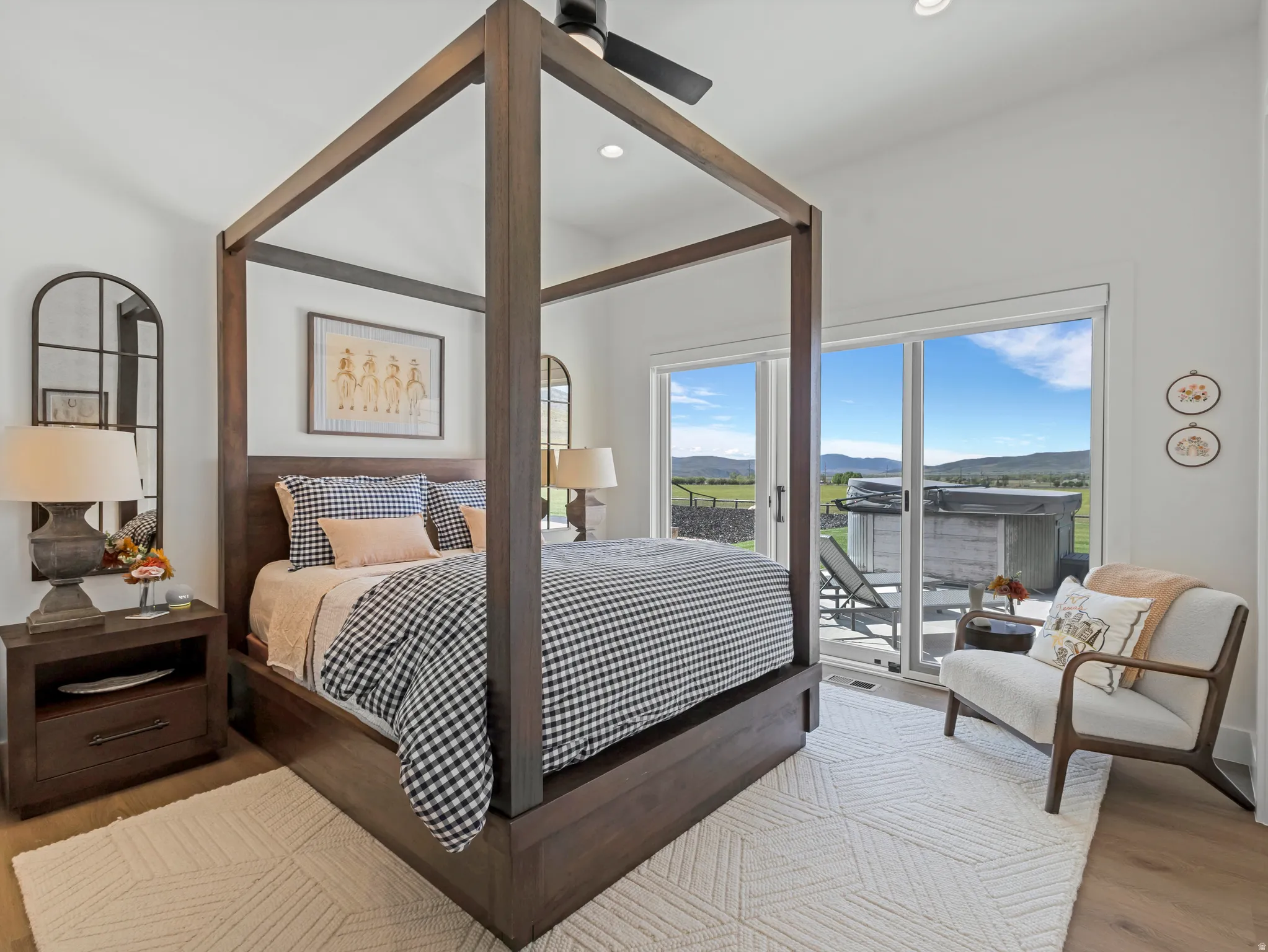 Spacious bedroom featuring wood-finish flooring, recessed lighting, and a dark wood four-poster bed frame