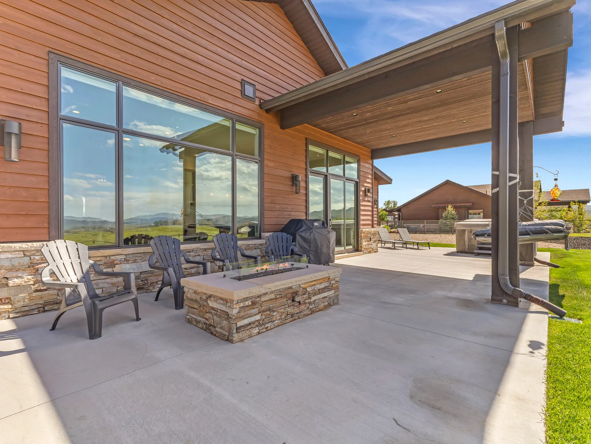 Expansive concrete patio with a built-in stone fire pit
