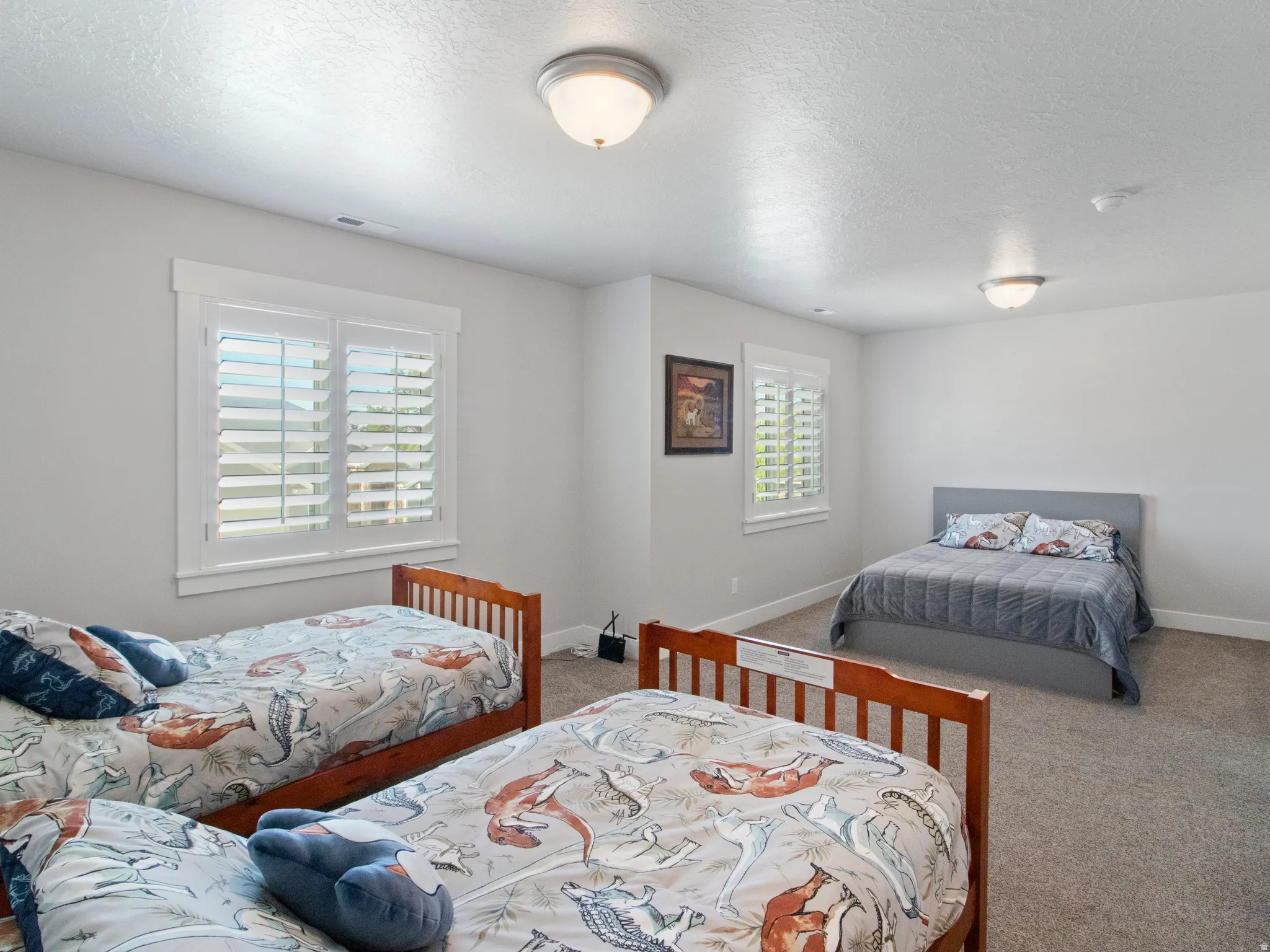 Carpeted room featuring multiple windows with louvered shutters and white trim