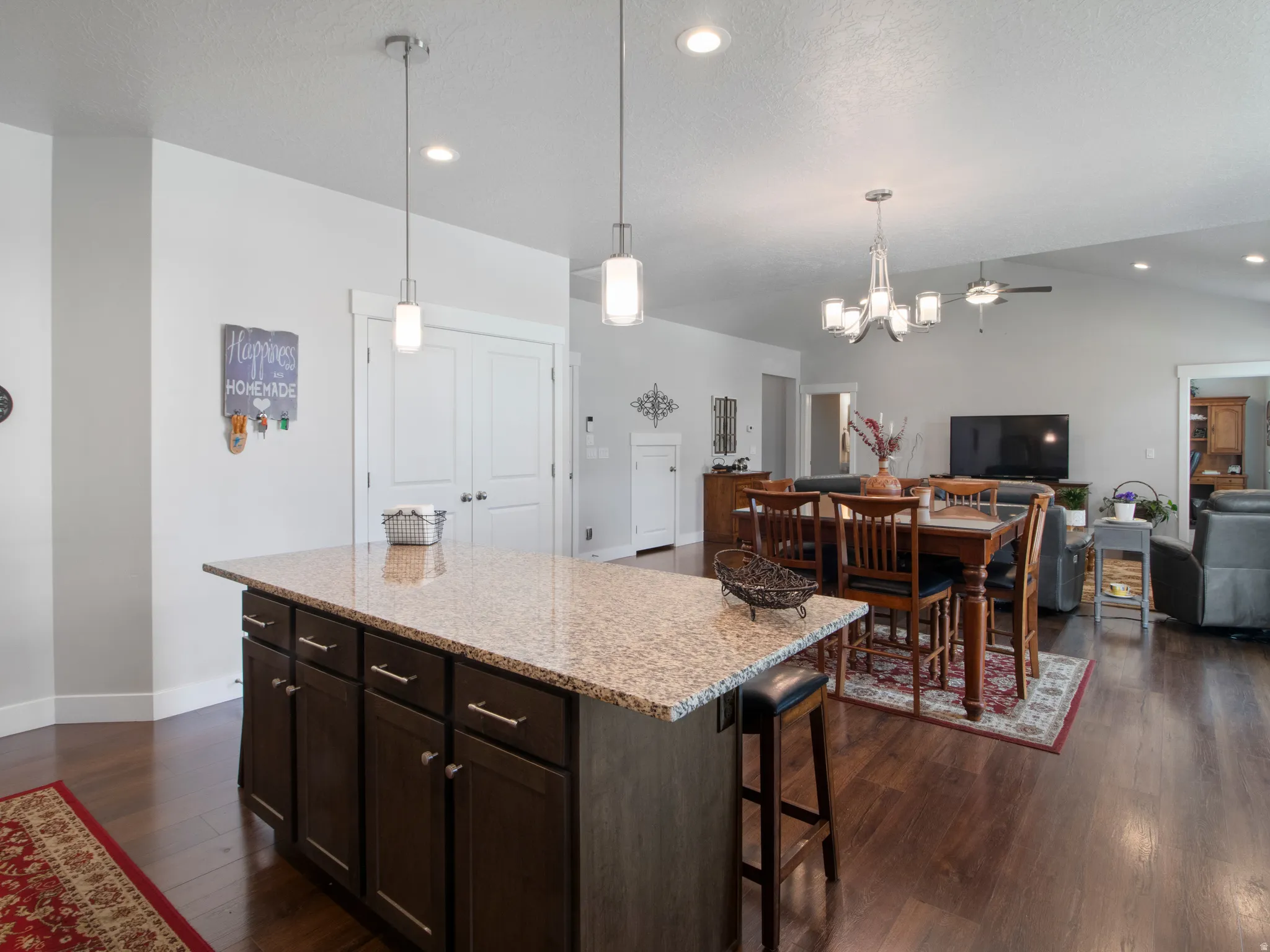 Kitchen island featuring a speckled countertop, dark wood-finish cabinetry, and built-in breakfast bar