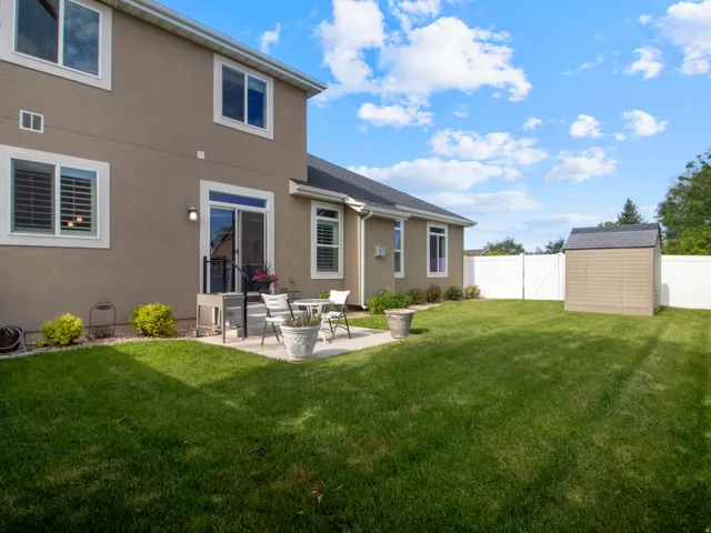 Expansive backyard featuring a manicured lawn, a concrete patio, and a privacy fence