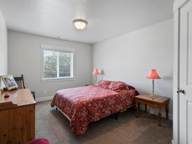 Bedroom featuring neutral wall paint, textured ceiling, and carpet flooring
