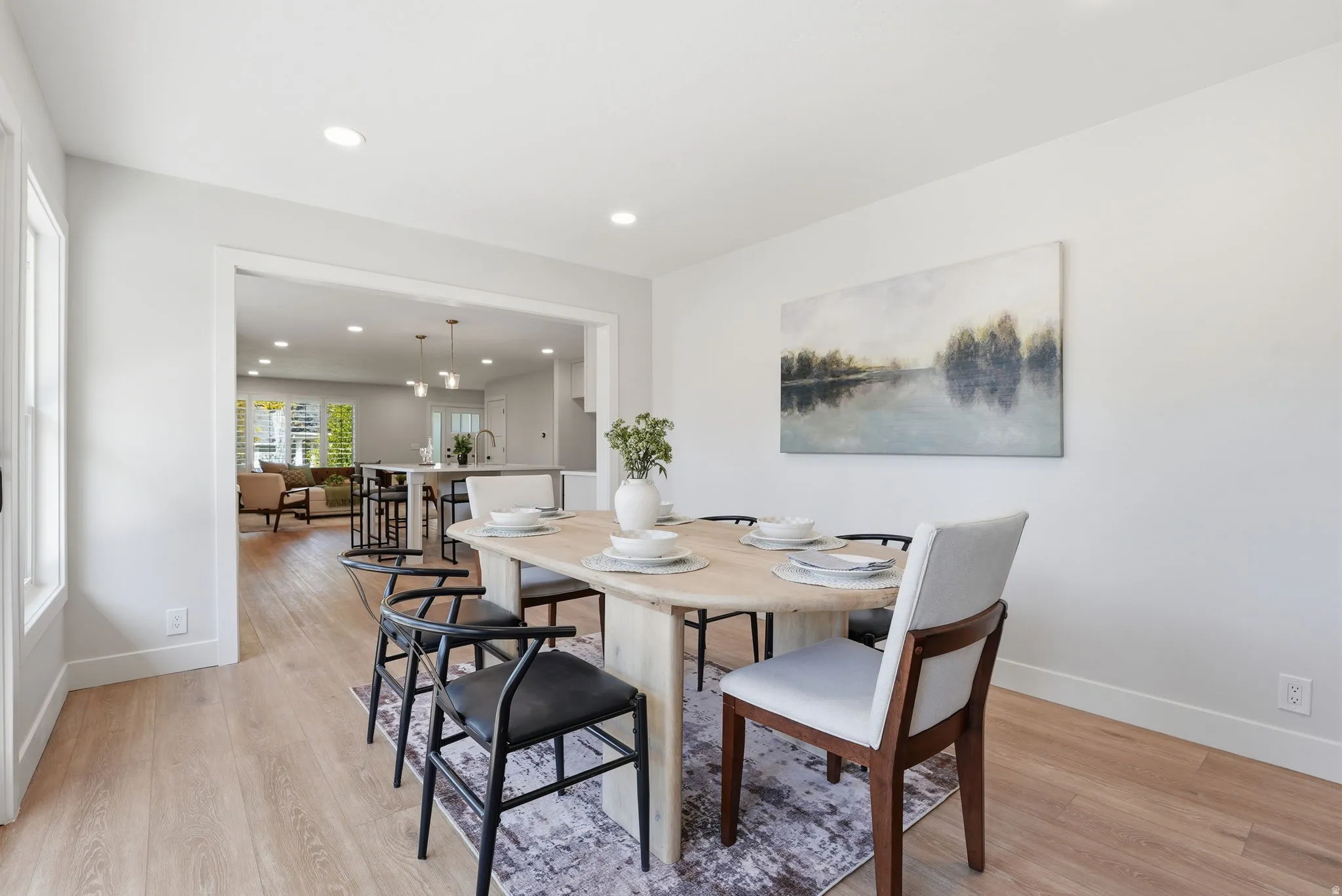 Open-concept dining area featuring light wood-finish flooring and recessed lighting