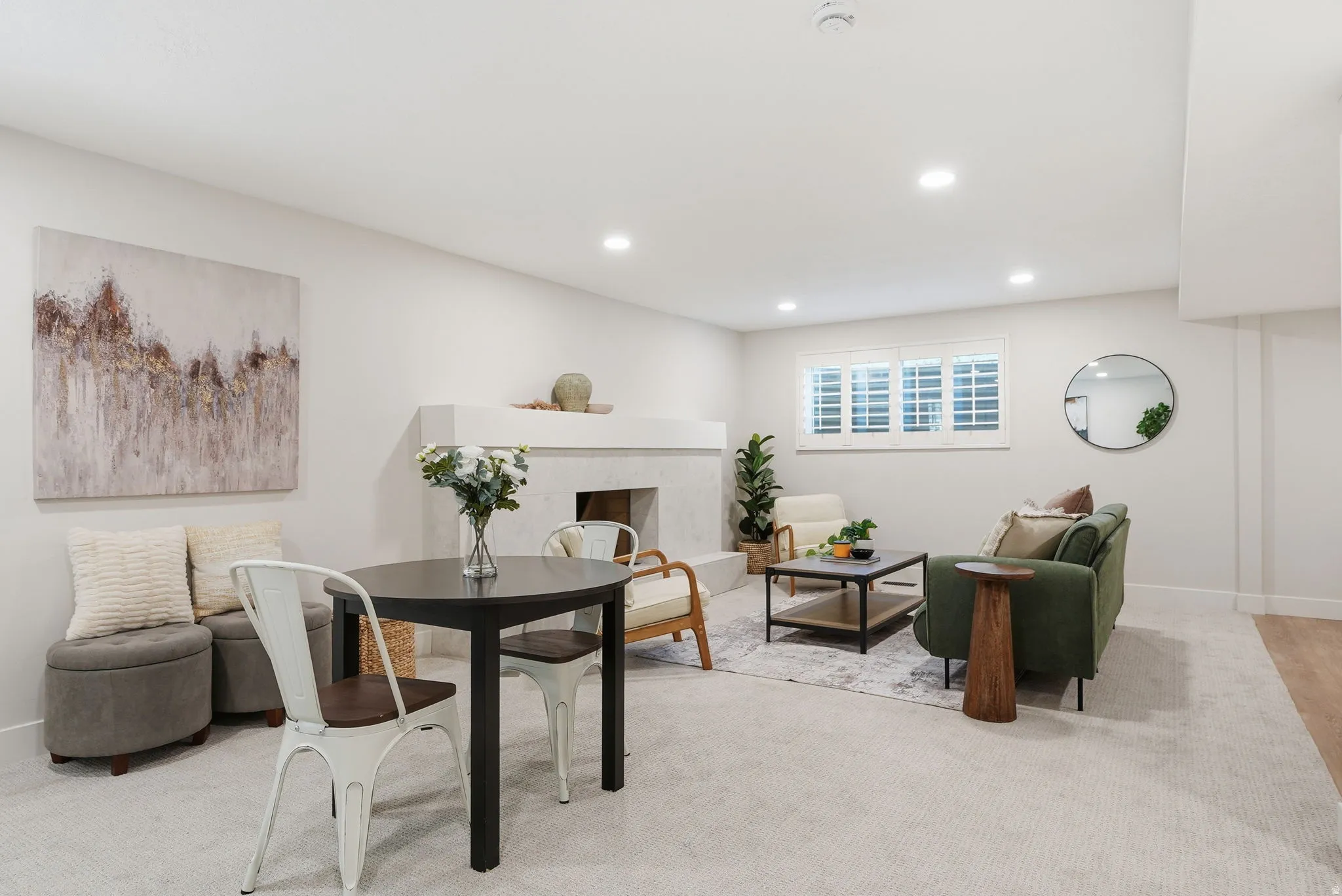 Spacious living area featuring recessed lighting, a built-in fireplace, and a window with plantation shutters