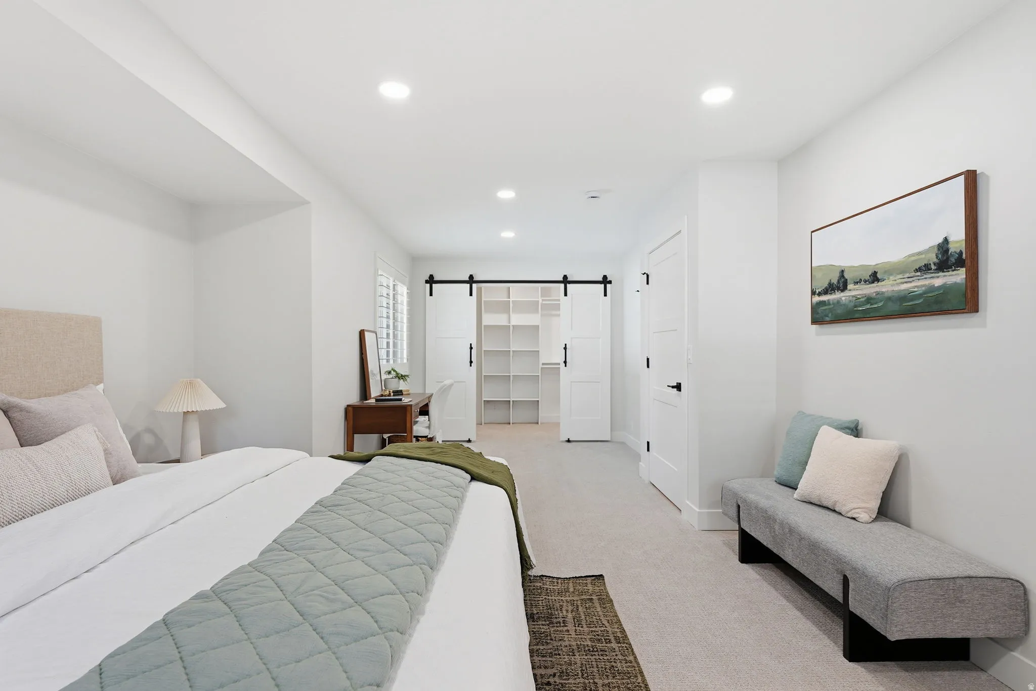 Spacious interior room featuring light-colored carpeting, recessed lighting, and white walls