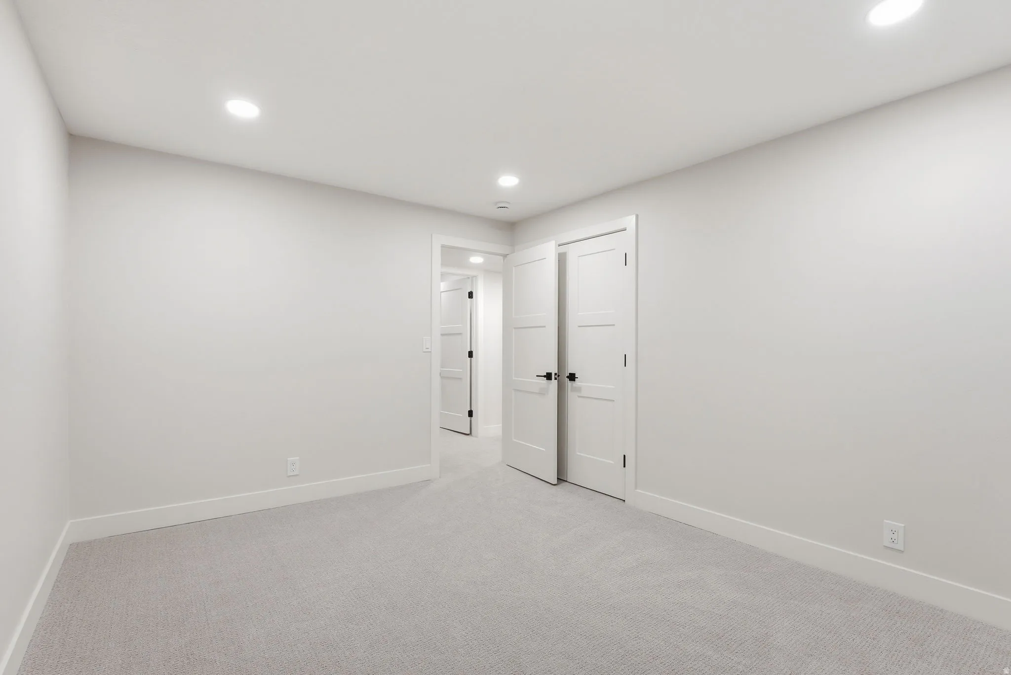 Neutral-toned room with light gray carpet flooring and white baseboards