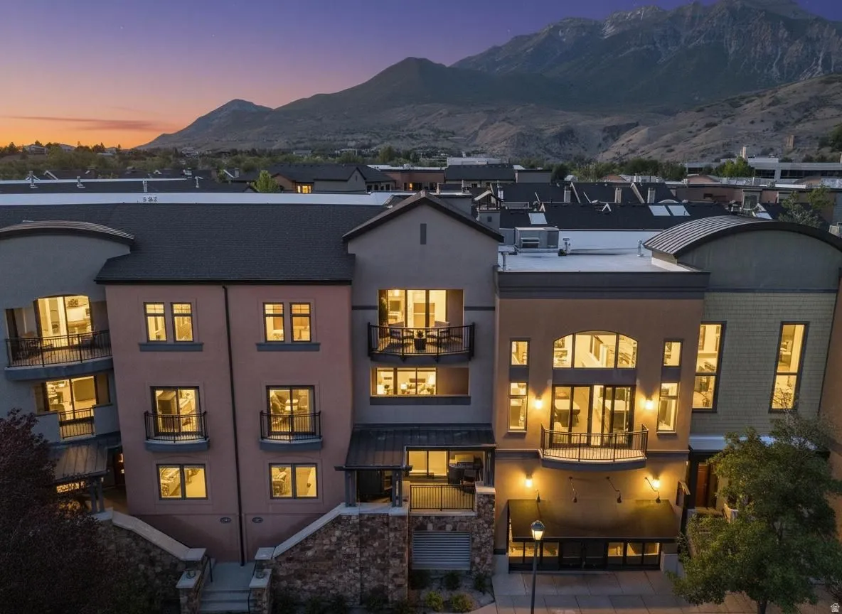 Multi-story building exterior featuring varied facades and a mountain backdrop