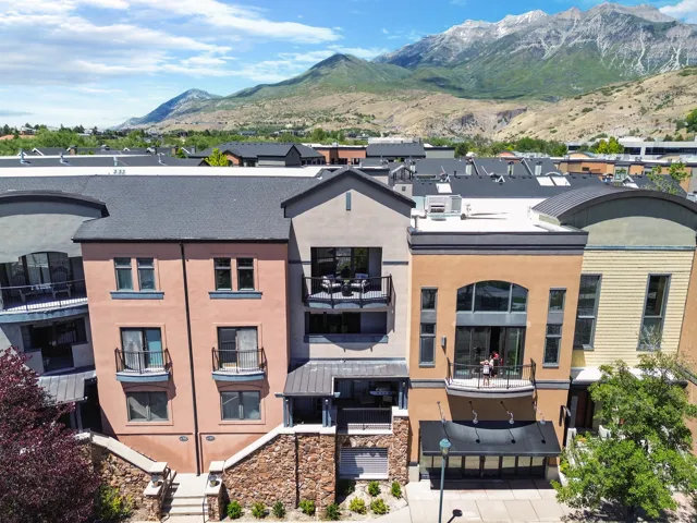 Three-story townhome with a stucco exterior, multiple private balconies, and an arched window façade