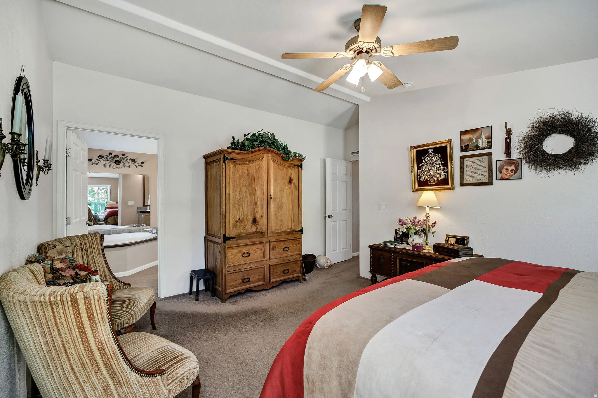 Carpeted bedroom with a vaulted ceiling and a ceiling fan with integrated lighting