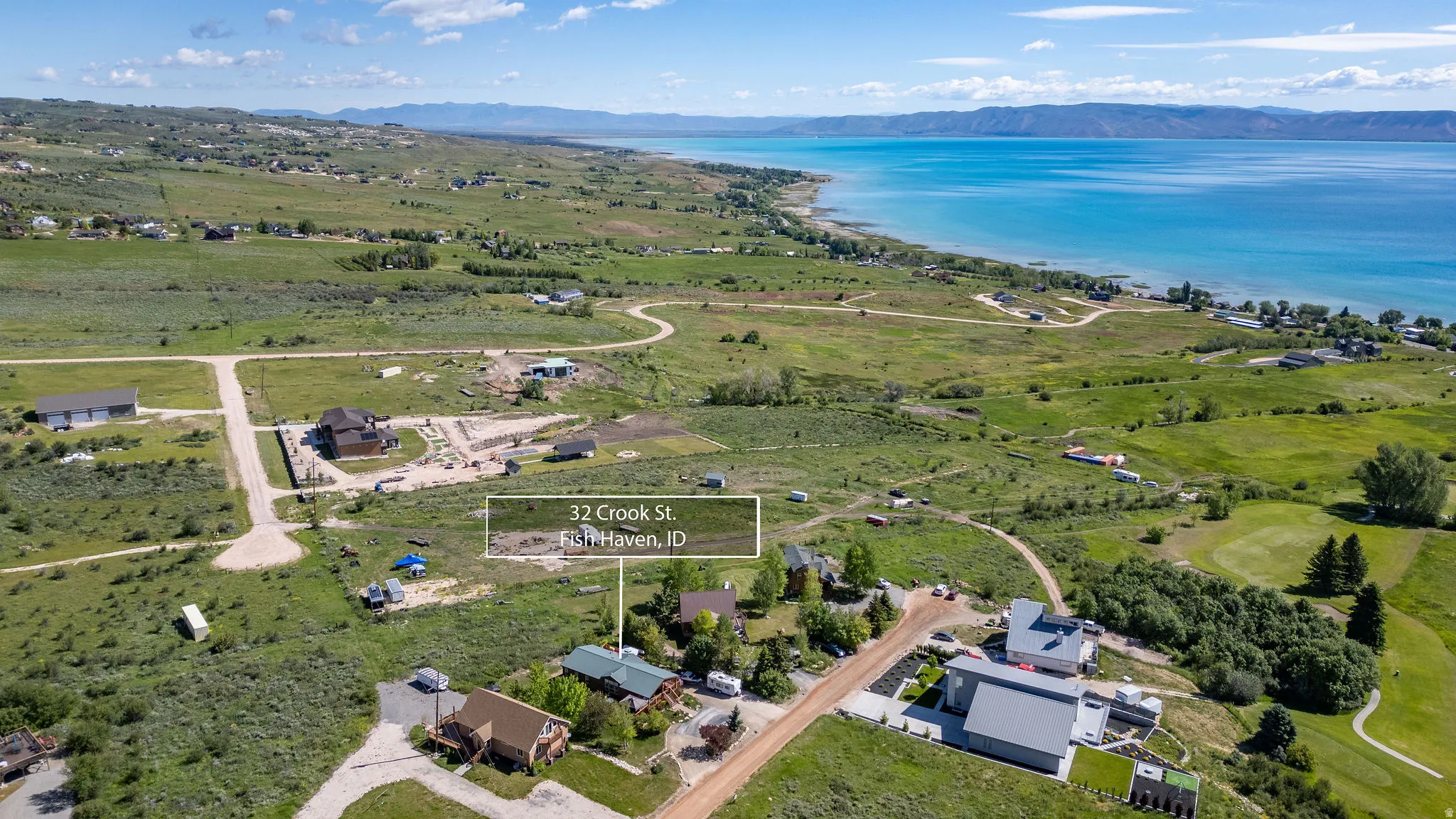 Aerial perspective showcasing a large body of water, distant mountains, and verdant green landscapes