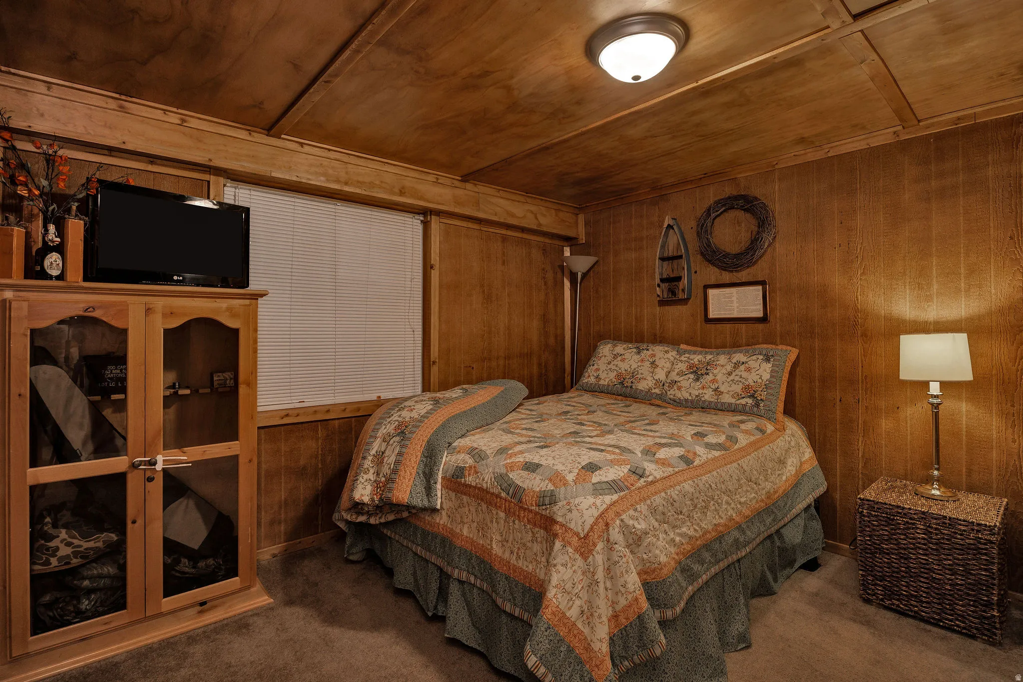 Wood-paneled room featuring a window with horizontal blinds, overhead flush mount lighting, and wood-finish flooring