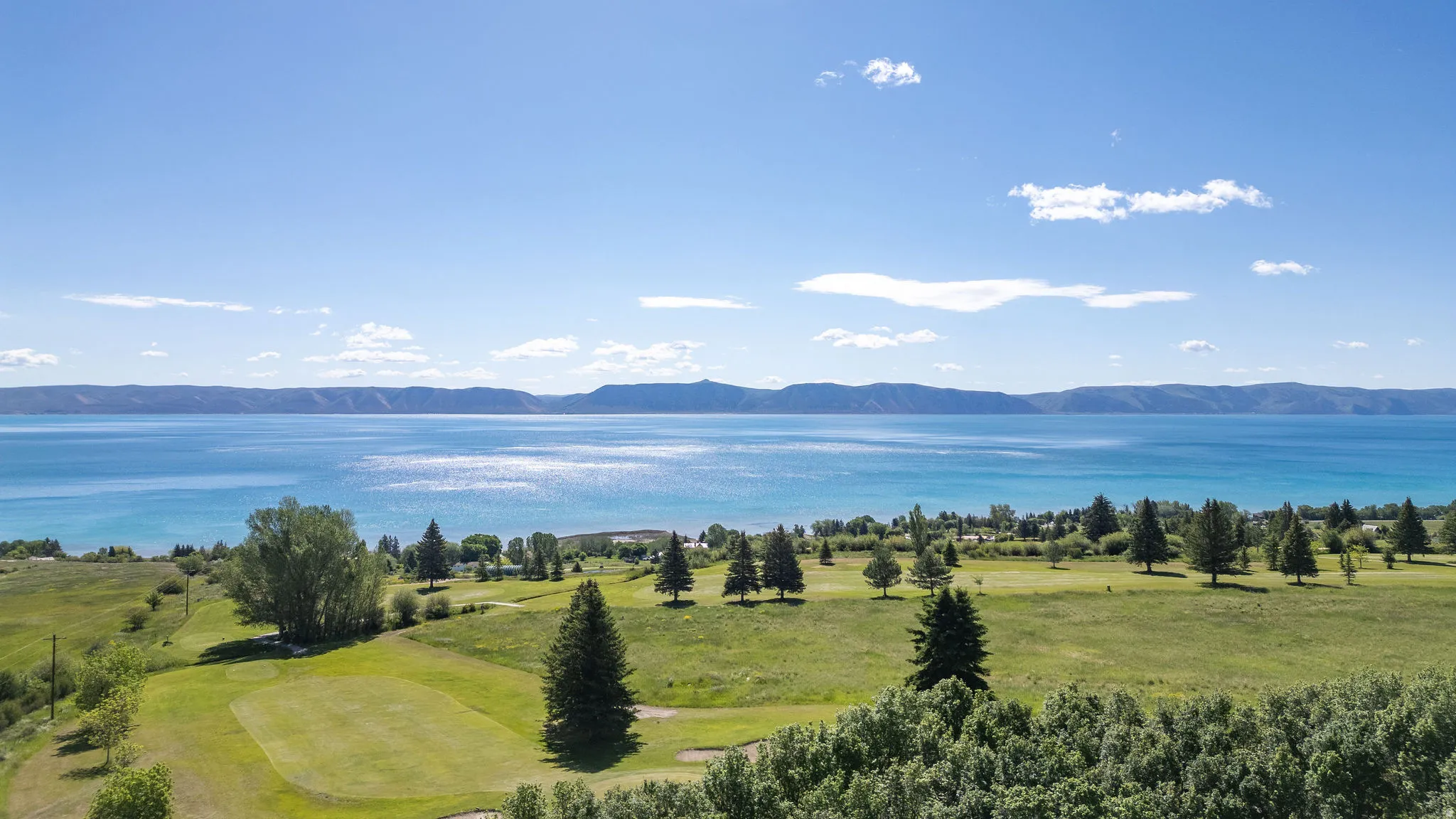Expansive body of water with a distinct blue hue, framed by distant mountains