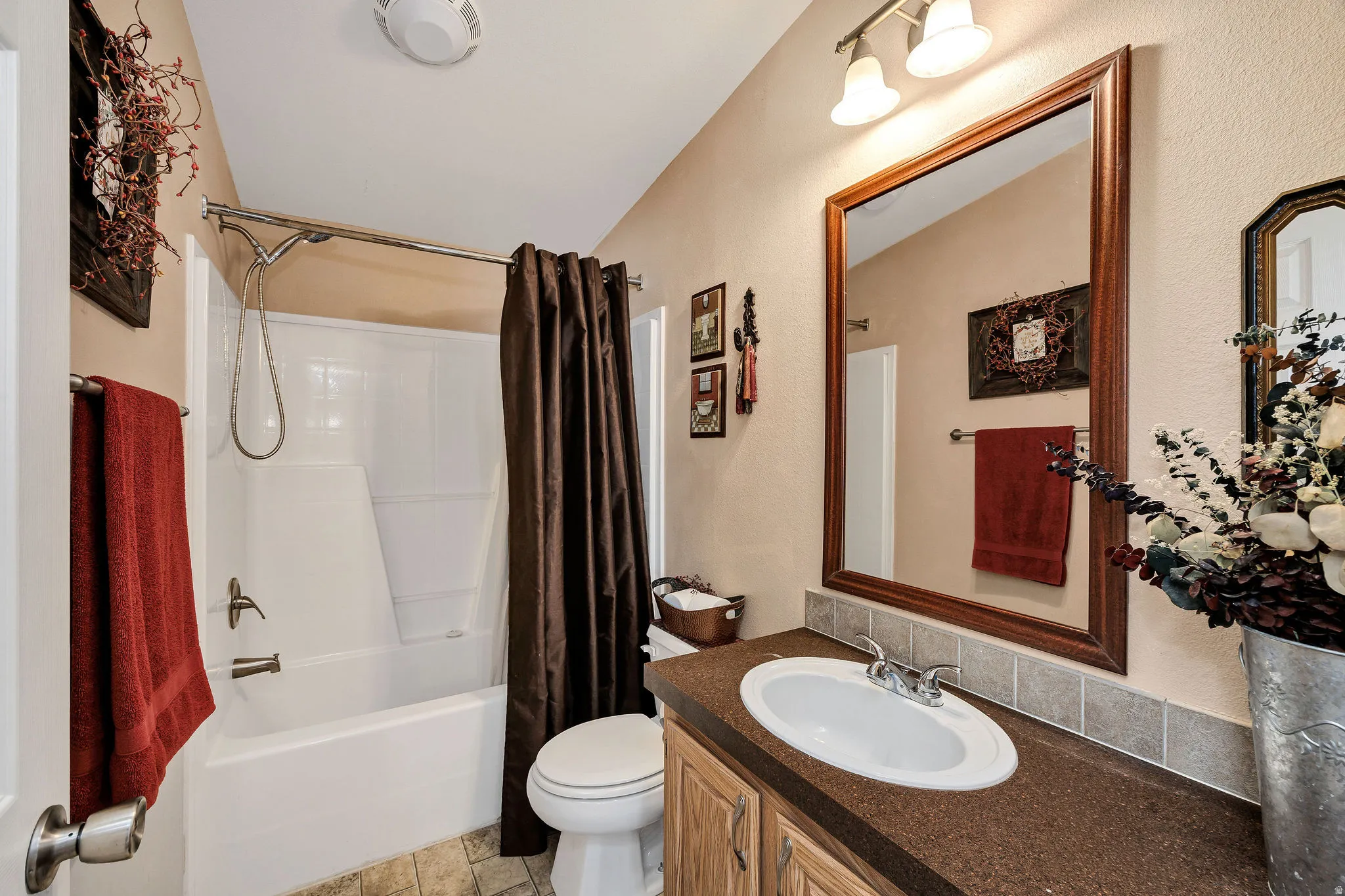Bathroom featuring a white tub/shower combination, a vanity with an integrated sink, a framed mirror, and wood-finish flooring