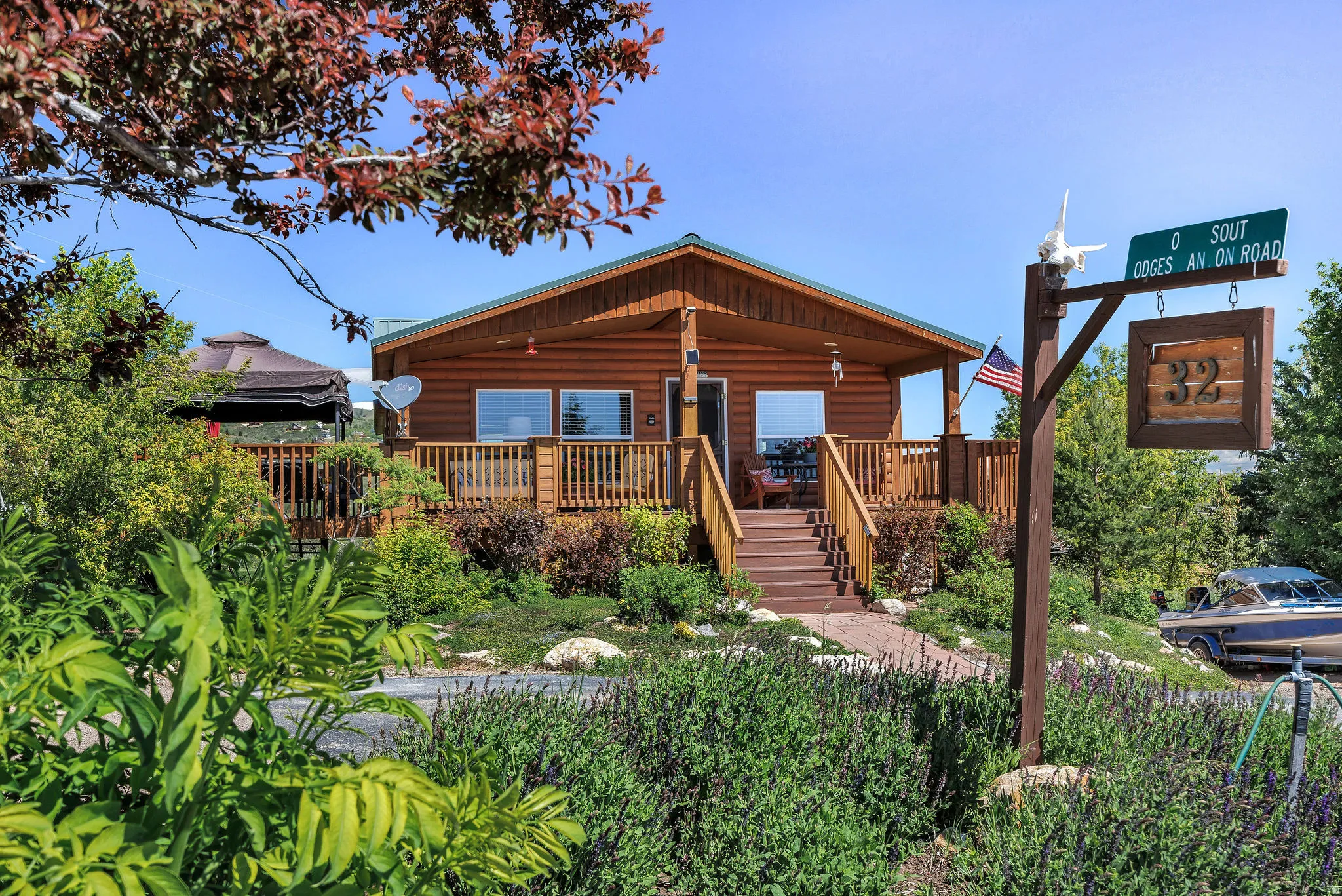 Log-sided residence with a covered porch, wood deck, and an extensive surrounding landscape
