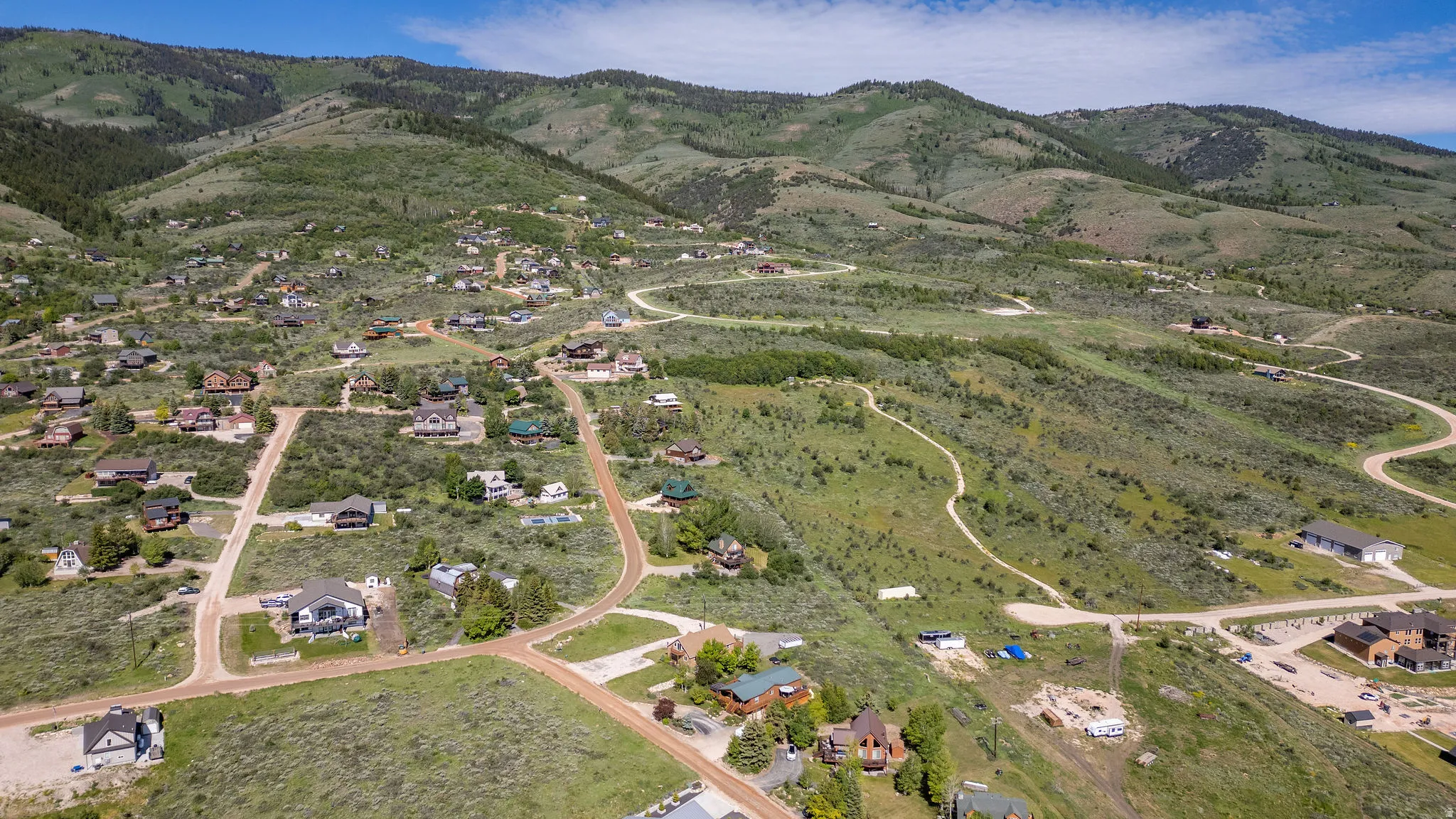 Expansive mountain landscape featuring varied terrain and multiple residential properties