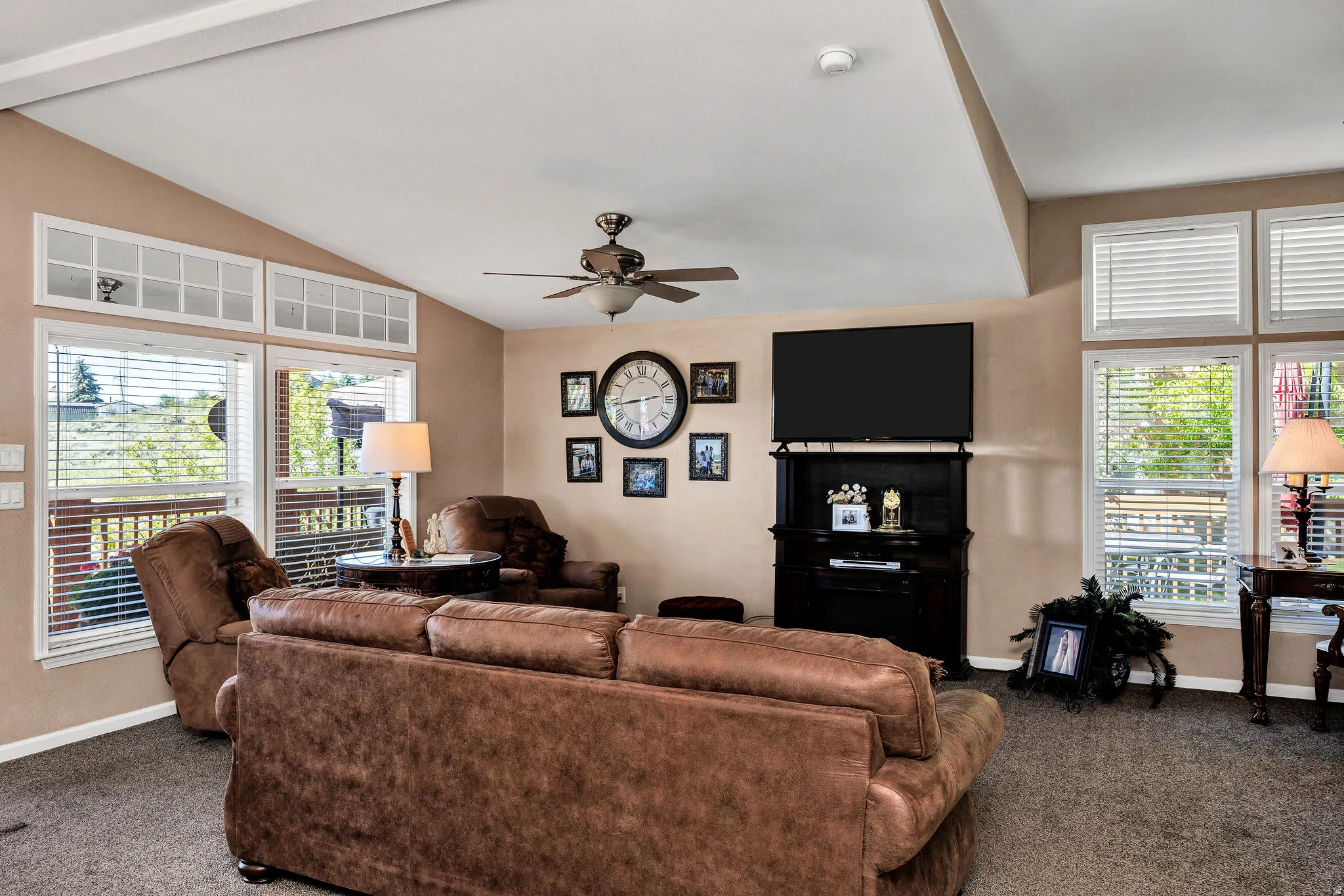 Living area featuring vaulted ceilings, recessed lighting, and a ceiling fan