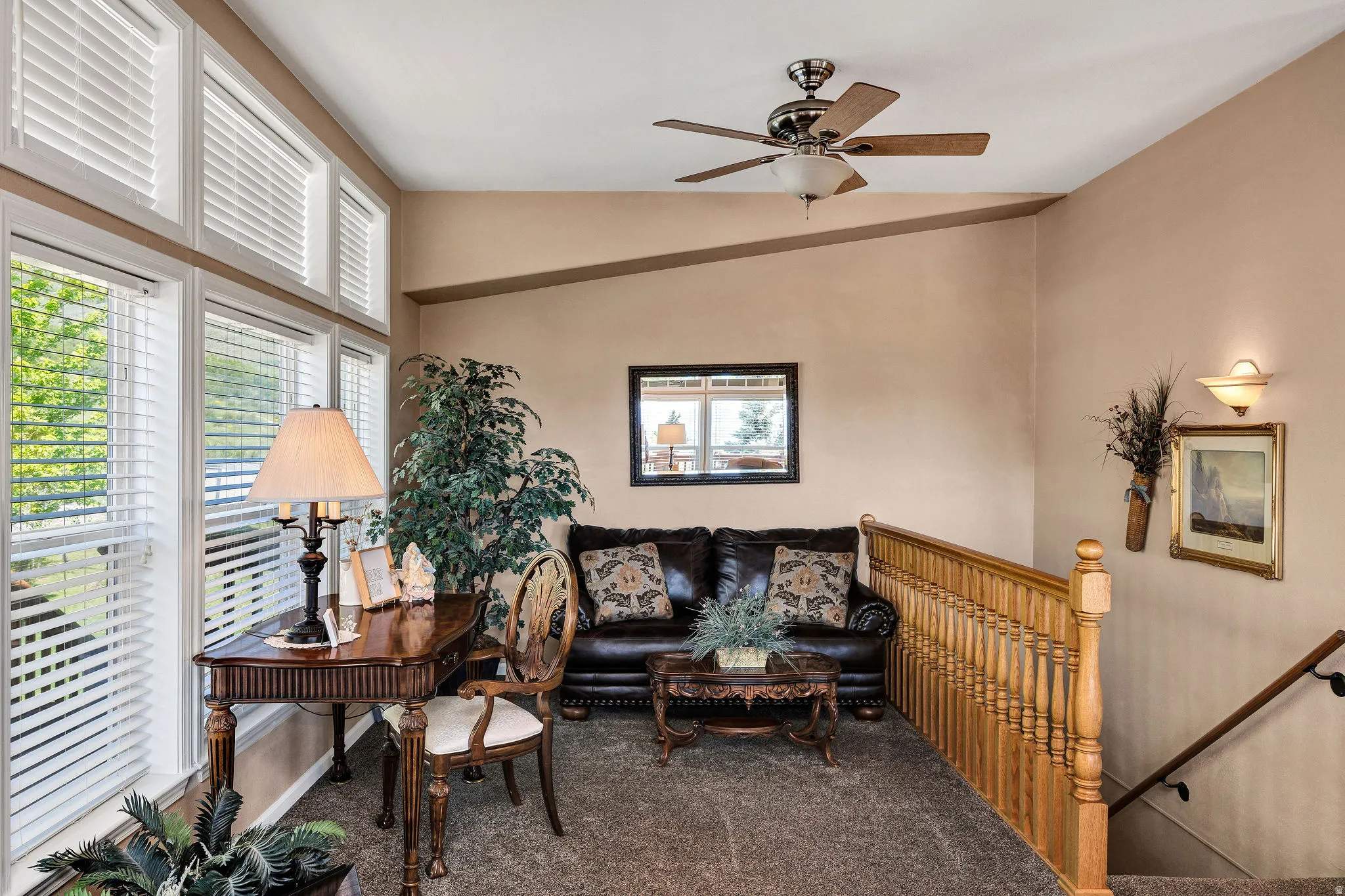Upper-level landing featuring a vaulted ceiling and ample natural light from extensive fenestration