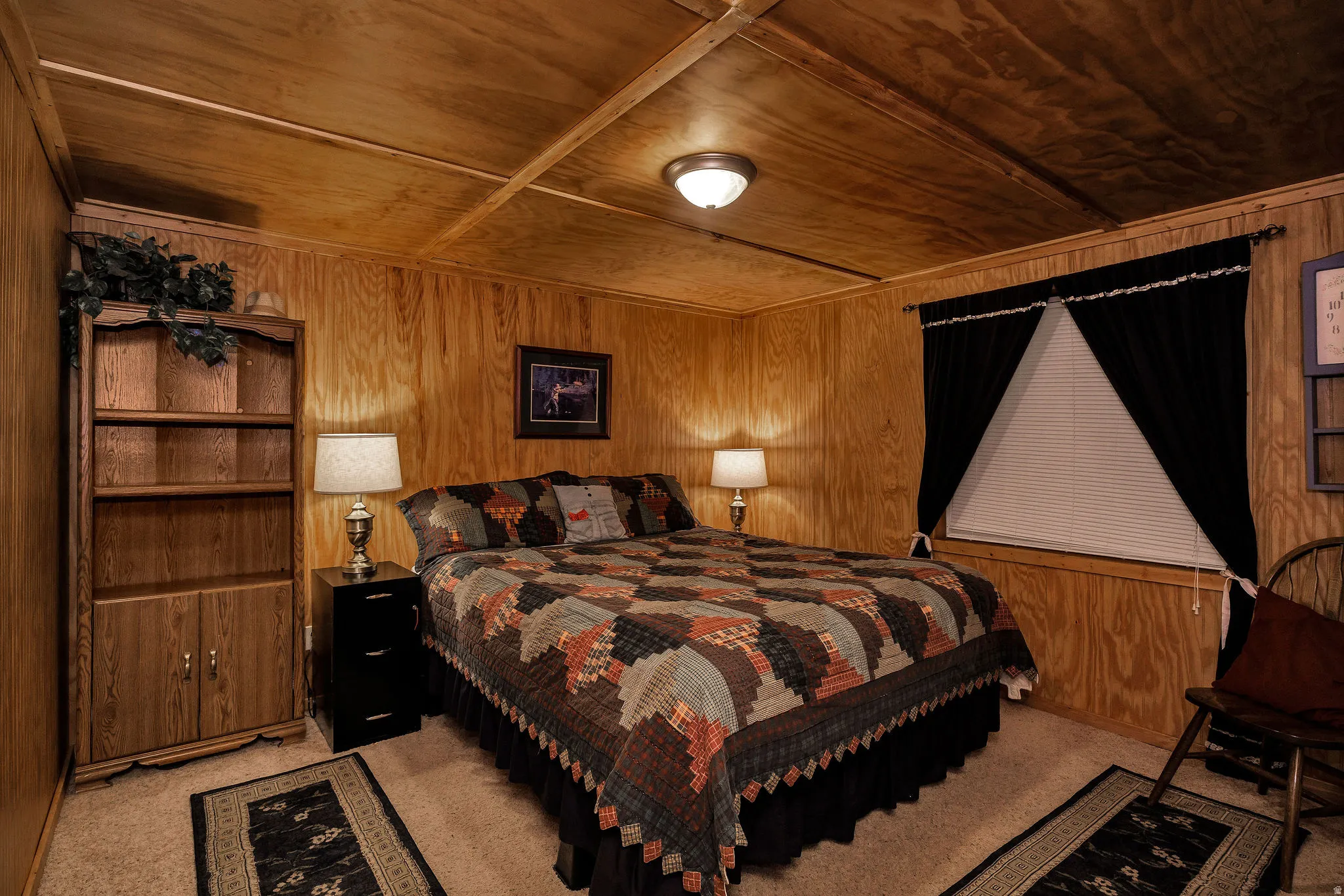 Bedroom featuring wood-finish wall paneling, a wood-finish slatted ceiling, and neutral carpeting