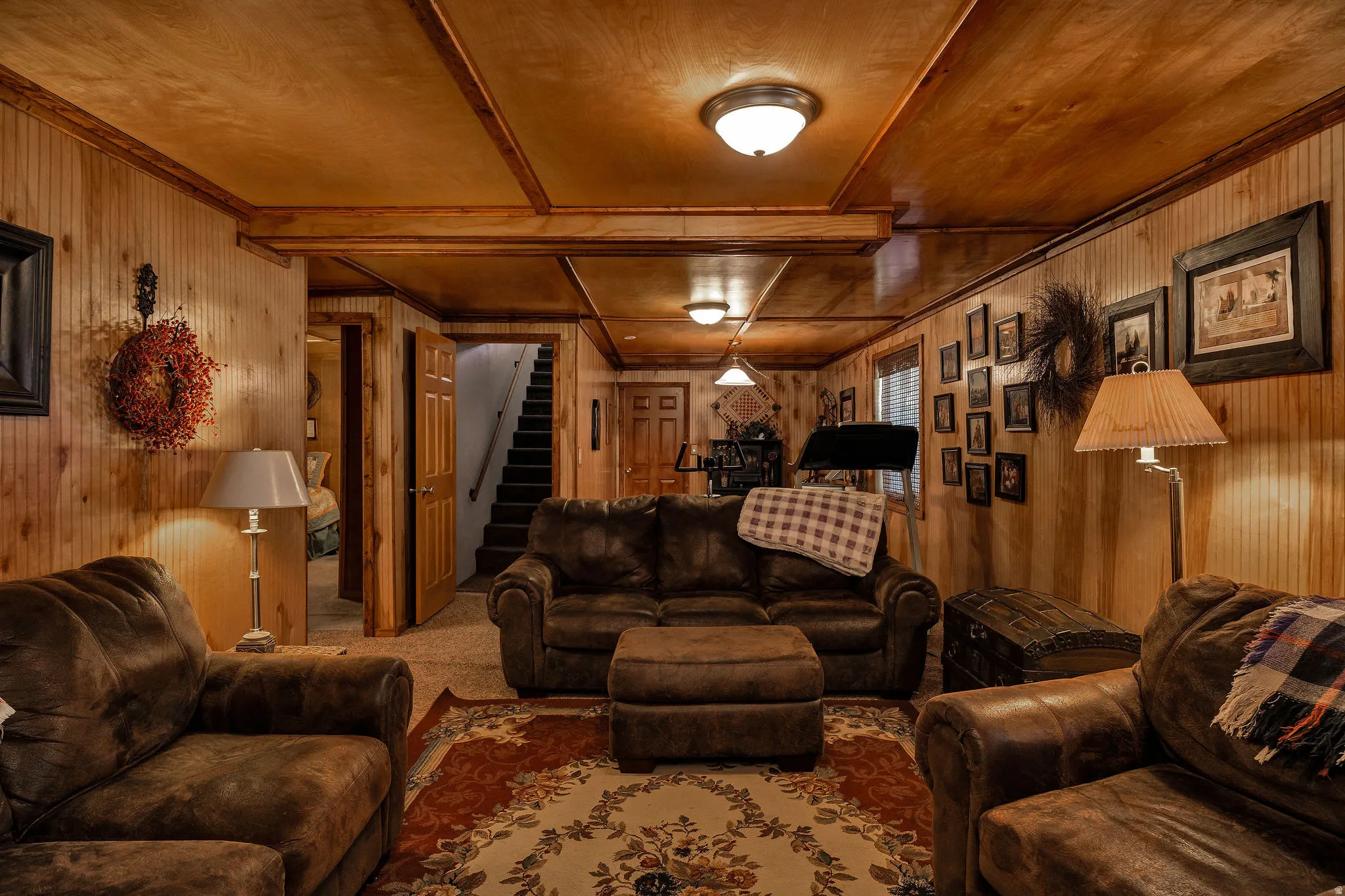 Finished lower level featuring extensive wood paneling, wood-finish ceiling, exposed wood beams, and recessed lighting