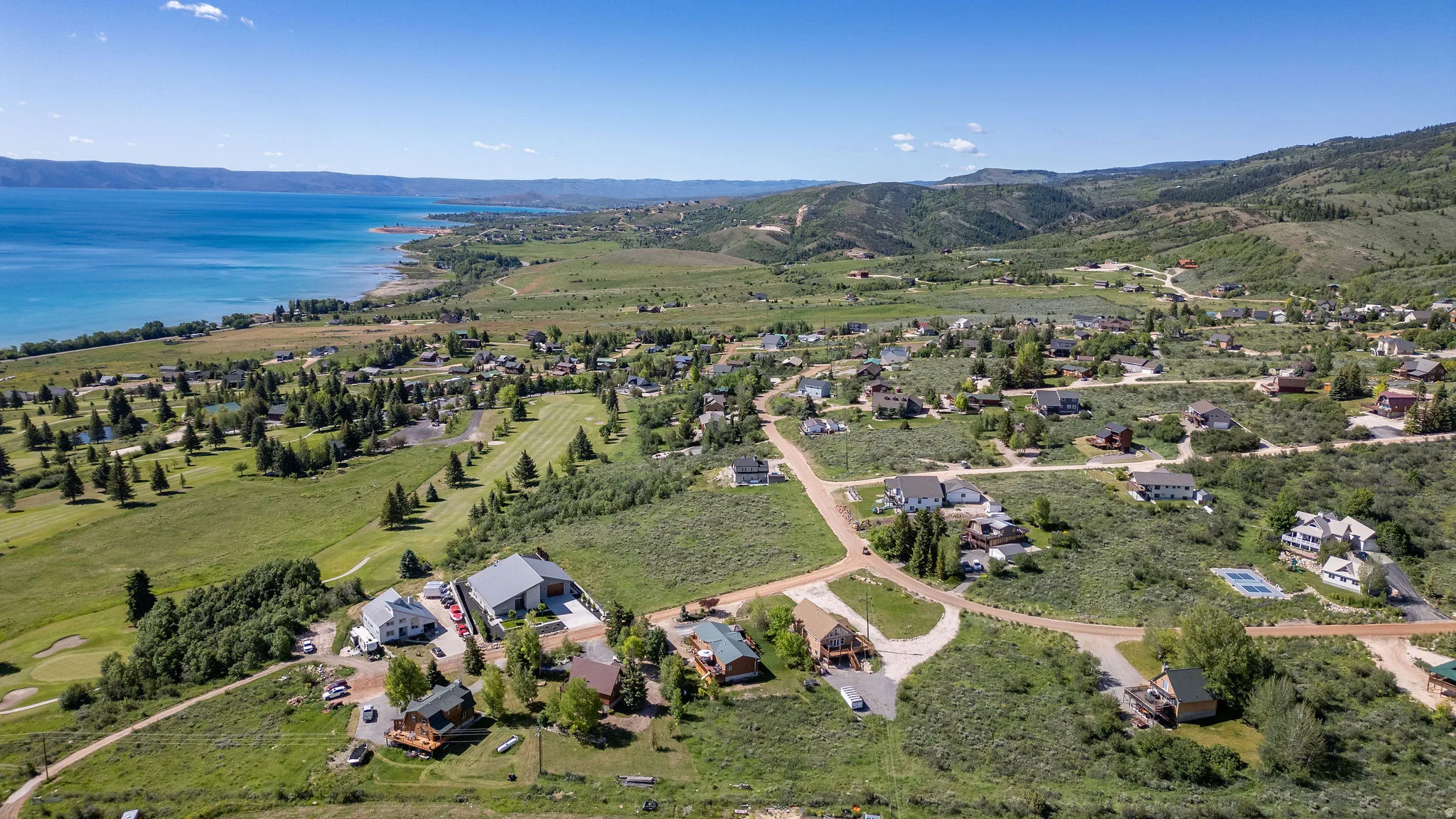 Expansive aerial showcasing a lakeside community with surrounding mountains