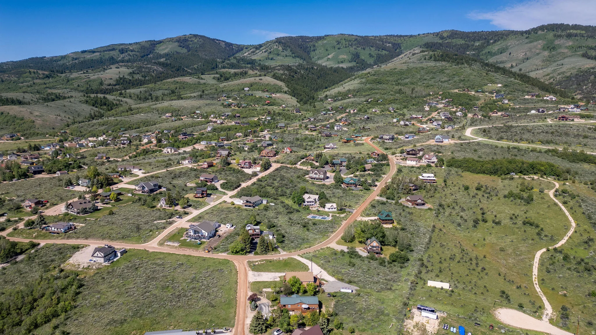 Expansive mountain landscape featuring numerous residential properties and winding roads