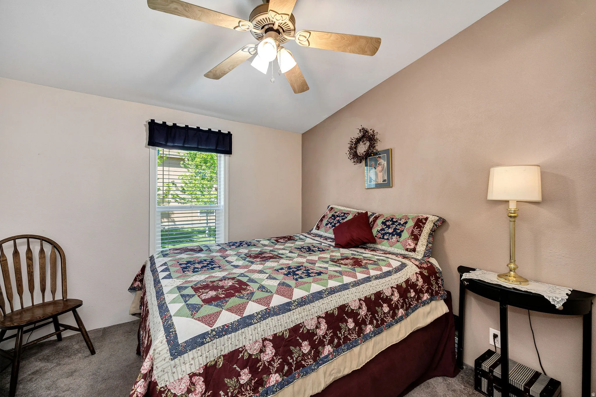 Carpeted room featuring a ceiling fan with integrated lighting, a window with blinds, and painted walls