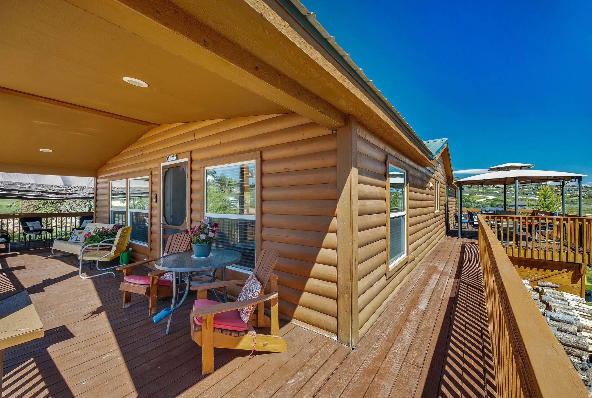 Expansive wood-finish deck featuring a covered porch with recessed lighting