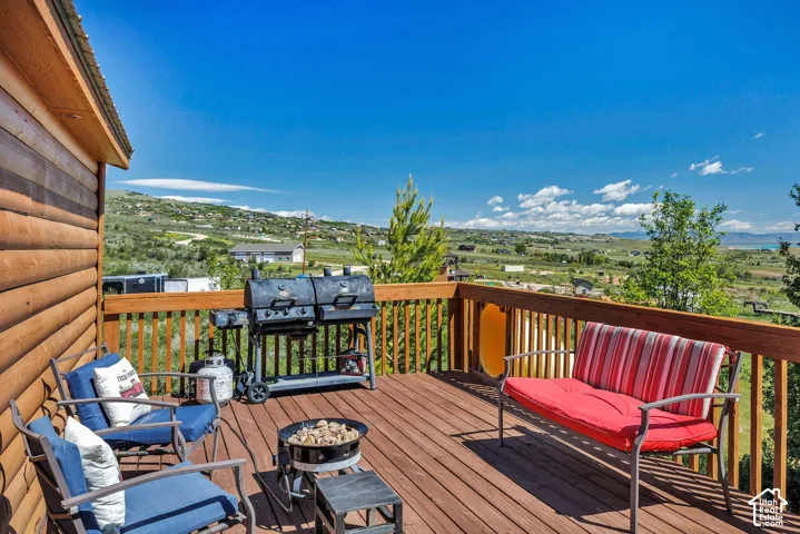 Expansive wood deck with a durable wood railing, featuring a log cabin style exterior wall