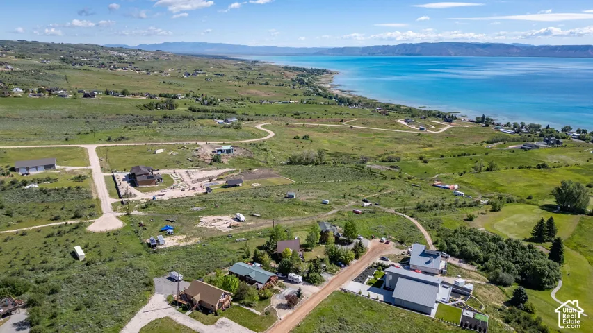 Expansive land plots featuring a winding dirt road and scattered residential structures