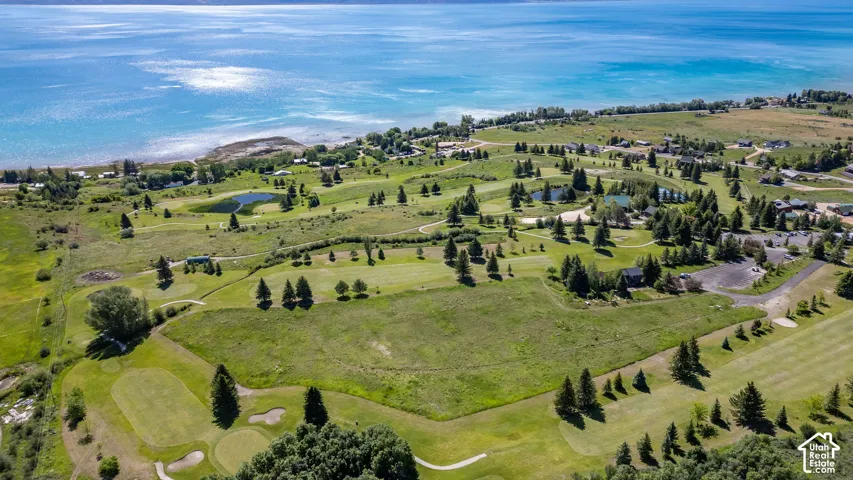 Expansive waterfront landscape featuring a golf course, multiple water features, and a variety of mature trees