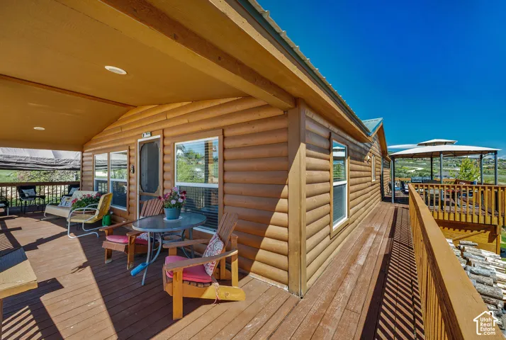 Expansive wood-finish deck featuring a covered porch with recessed lighting