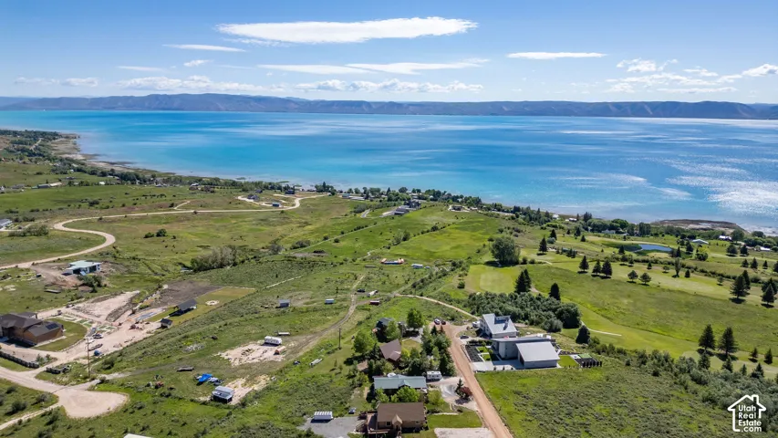 Expansive land parcel featuring distant mountain ranges and a large body of water with a shoreline