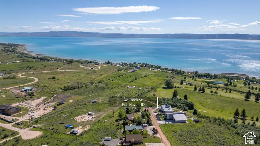Expansive waterfront property with a large body of water, rolling hills, and distant mountains