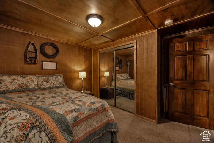 Wood-paneled room featuring a flush-mount ceiling light, wall paneling, and a mirrored closet door