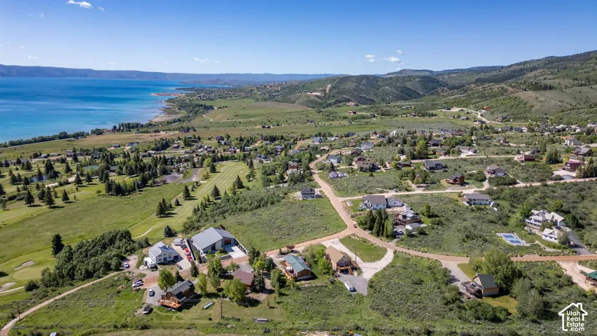 Expansive aerial showcasing a lakeside community with surrounding mountains