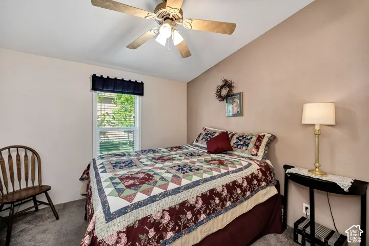 Carpeted room featuring a ceiling fan with integrated lighting, a window with blinds, and painted walls