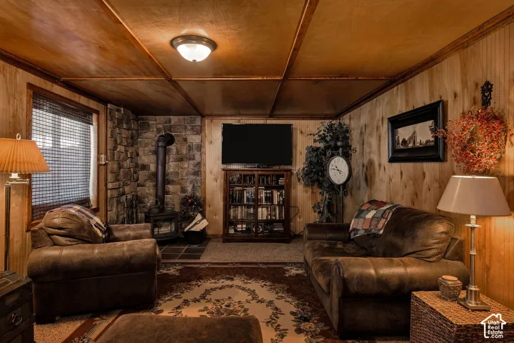 Living area with wood paneling, wood-finish ceiling, and a prominent stone accent wall