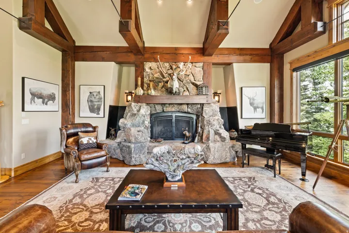 Spacious living area featuring a stone-clad fireplace with a timber mantel