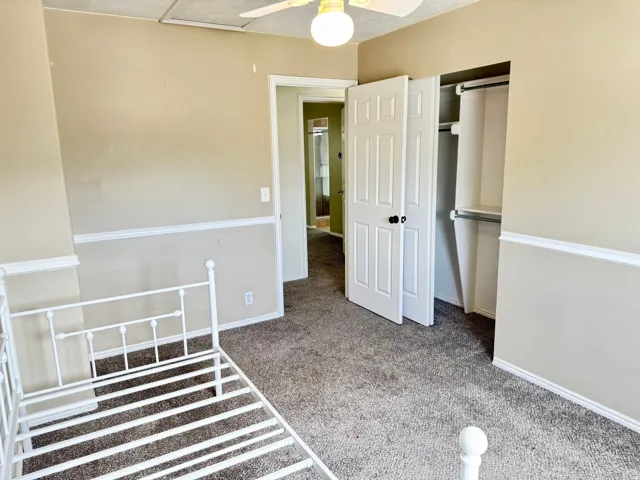 Carpeted room with neutral painted walls featuring white chair rail molding