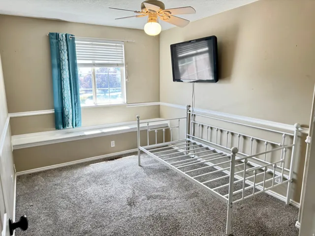 Carpeted room featuring a window with blinds, a window seat, and crown molding